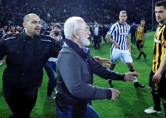 Grieķijas futbola derbijā starp PAOK un AEK, kas noslēdzās ar rezultātu 0:0, spēles izskaņā izcēlās īsts trilleris. PAOK mača beigās guva vārtus, bet AEK spēlētāji to apstrīdēja, norādot, ka tie gūti no aizmugures stāvokļa. Tiesnesis pieņēma lēmumu vārtus neieskaitīt, kas sadusmoja PAOK līdzjutējus un kluba īpašnieku. Kluba prezidents Ivans Savvidis dusmās izskrēja laukumā, bet viņam līdzi pie jostas sāniem bija pistole.