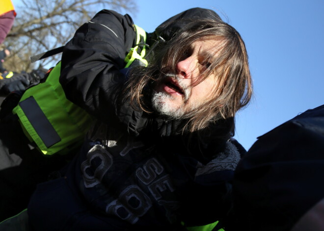 Leģionāru piemiņas gājiena laikā pie Brīvības pieminekļa policija aiztur kādu piketētāju, kurš rokās turēja plakātu ar bildi, kurā bija redzams kadrs no kādās nacistiskās koncentrācijas nometnes, un angļu valodā izsauca saukļus.