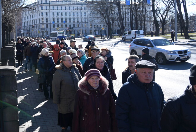 Cilvēki stāv rindā pie Krievijas vēstniecības ēkas, kur iespējams nobalsot Krievijas prezidenta vēlēšanās.