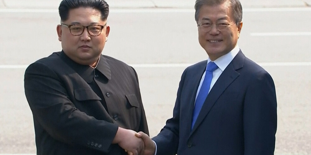 FOTO: abu Koreju līderi vēsturiski sarokojas uz valstu robežas