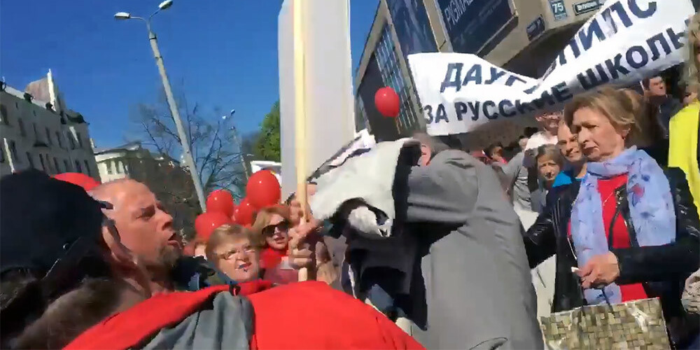 Drosmīgs latvietis ar zīmīgu plakātu pamanās iekļūt starp krievu skolu aizstāvju rindām