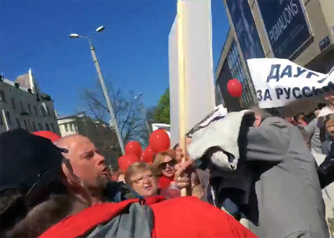 Drosmīgs latvietis ar zīmīgu plakātu pamanās iekļūt starp krievu skolu aizstāvju rindām