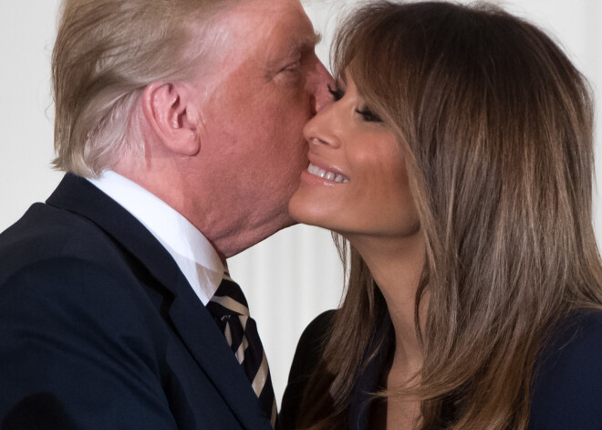 US President Donald Trump embraces First Lady Melania Trump (R) during an event in honor of Military Mothers and Spouses in the East Room of the White House in Washington, DC, May 9, 2018. / AFP PHOTO / SAUL LOEB