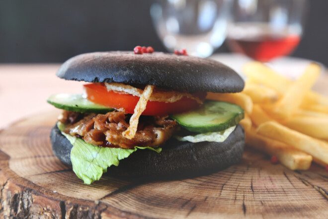 Andra Rūmīša burgers ar pīles konfitu, kas pasniegts melnajā burgermaizītē (interesantākam izskatam tās miltiem piejaukta sēpijas tinte). Pīles konfits (taukvielās ilgi un lēni sutināti pīles gabali, kas šķīst pa šķiedrām), ledus salāti, tomāts, gurķis, sīpolu marmelāde, eļļā cepti sīpoli, barbekjū mērce.