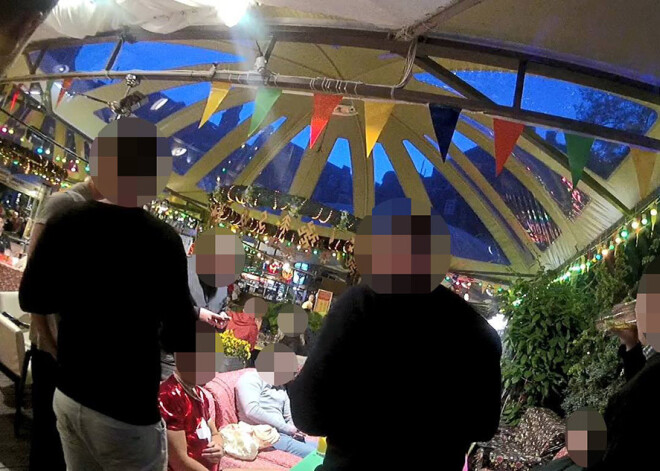 Britu tūristi Rīgas kafejnīcā ar piepūšamo lelli veic netiklas darbības