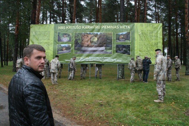 Andris Morozovs pie pašu izveidotā banera, kas aicināja ziedot līdzekļus NBS kritušo karavīru piemiņas vietas izveidei.