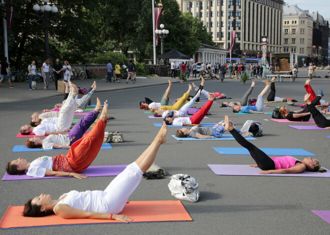 Jogas entuziasti meditē un praktizē pie Brīvības pieminekļa