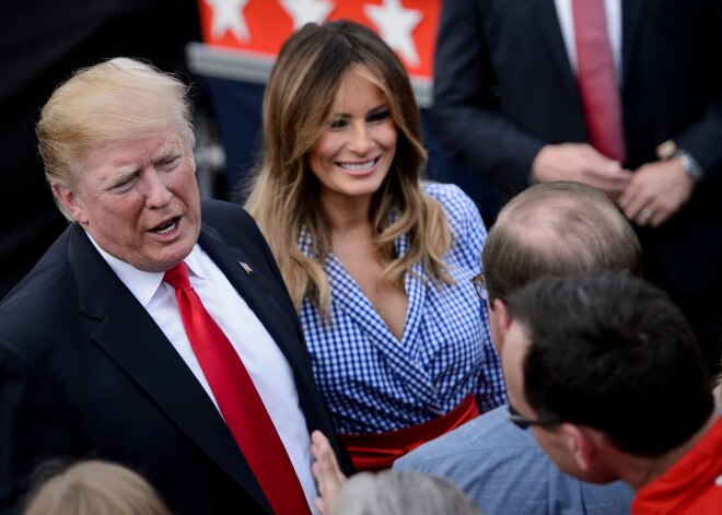 US President Donald Trump (L) and US First Lady Melania Trump greet guests during an Independence Day picnic for military families on the South Lawn of the White House July 4, 2018 in Washington, DC. / AFP PHOTO / Brendan Smialowski