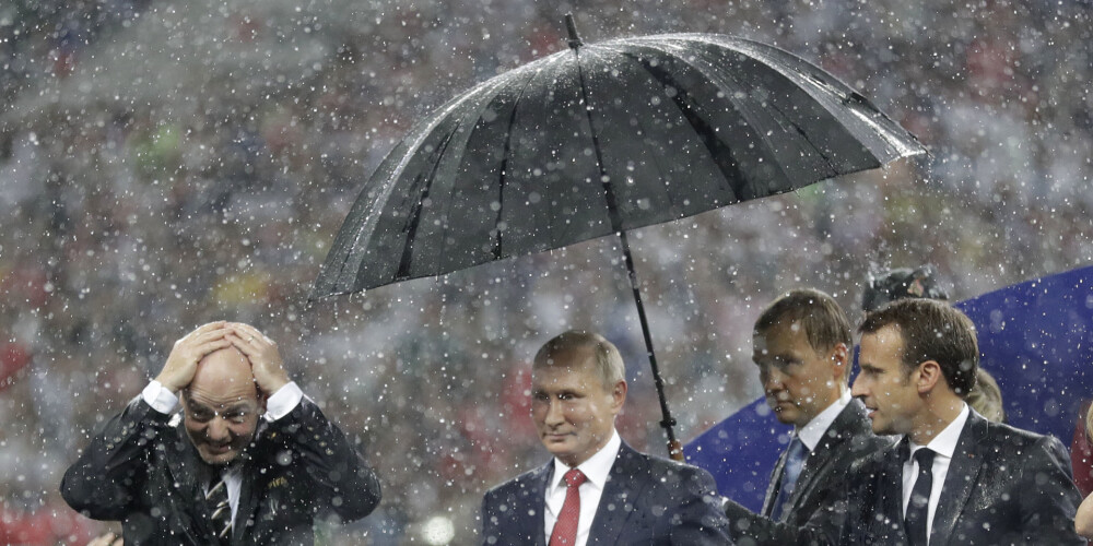 Pasaule smīn par amizantu skatu: neviesmīlīgais Putins zem lietussarga, bet Francijas un Horvātijas prezidenti izmirkuši līdz vīlei