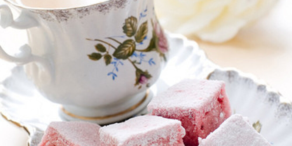 Cup of tea with milk served with strawberry cake. Selective focus