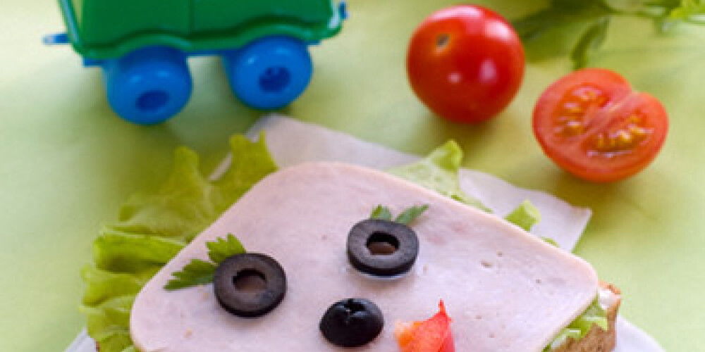 breakfast with ham and lettuce for child with toys on background