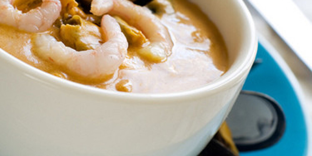 A bowl of seafood soup with shrimp and mussels. Shallow depth of field, selective focus