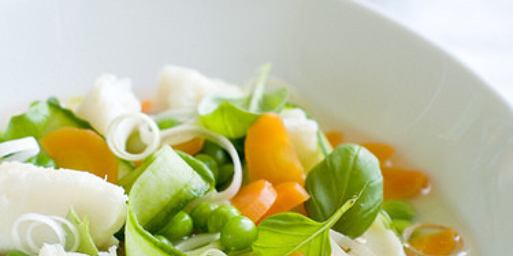 Vegetable soup with fish in a white plate