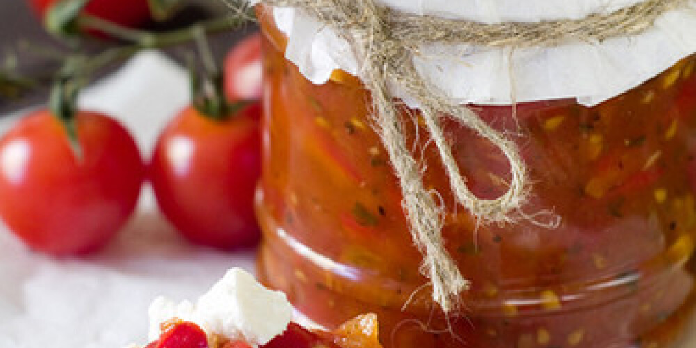 Tomato jam with pepper and garlic in glass jar. Selective focus, shallow doff