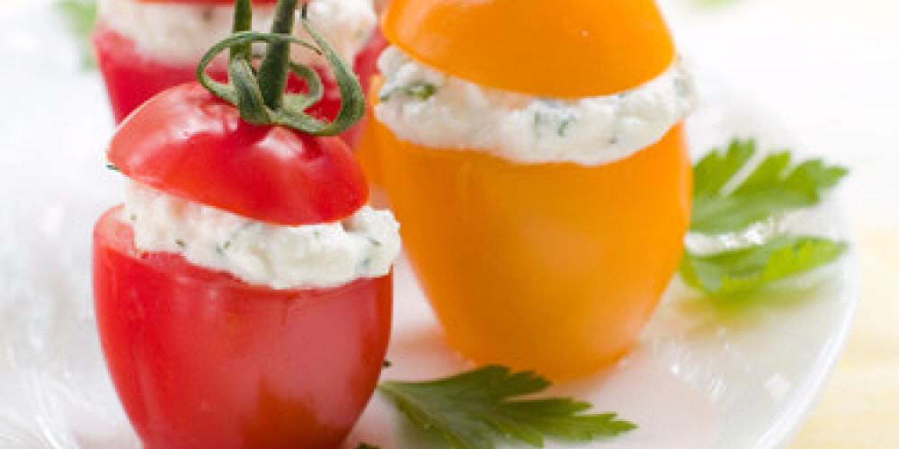 Red and yellow tomatoes stuffed with cottage cheese. Selective focus