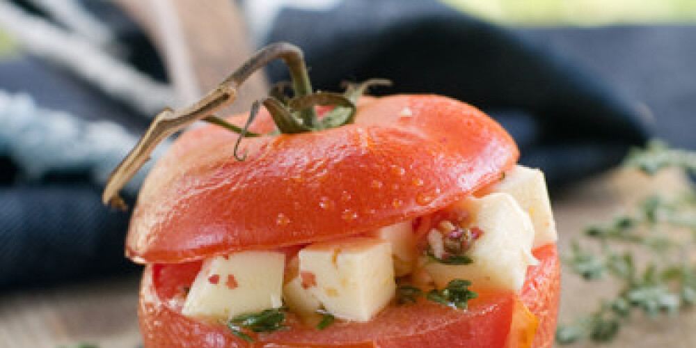 Stuffed tomatoes with cheese. Shallow DOF, selective focus .