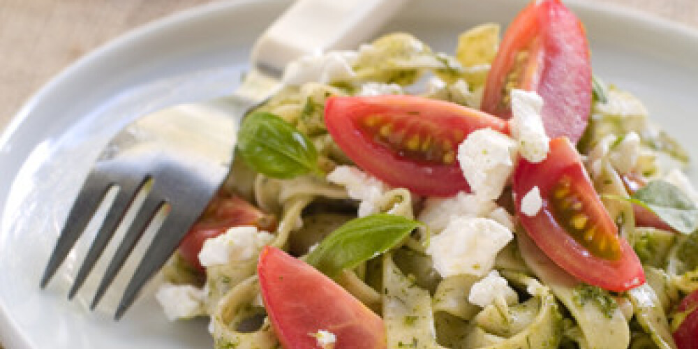 Tagliatelle pasta with pesto, tomato and cheese. Selective focus