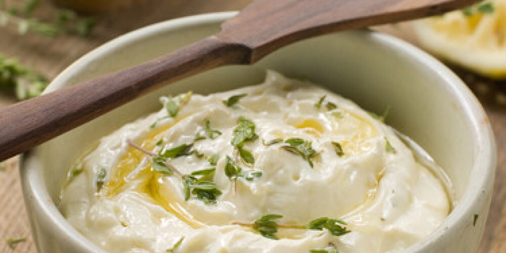 A bowl of cheese dip with thyme and olive oil. Selective focus