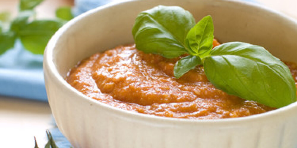 A bowl of roasted vegetable sauce with basil