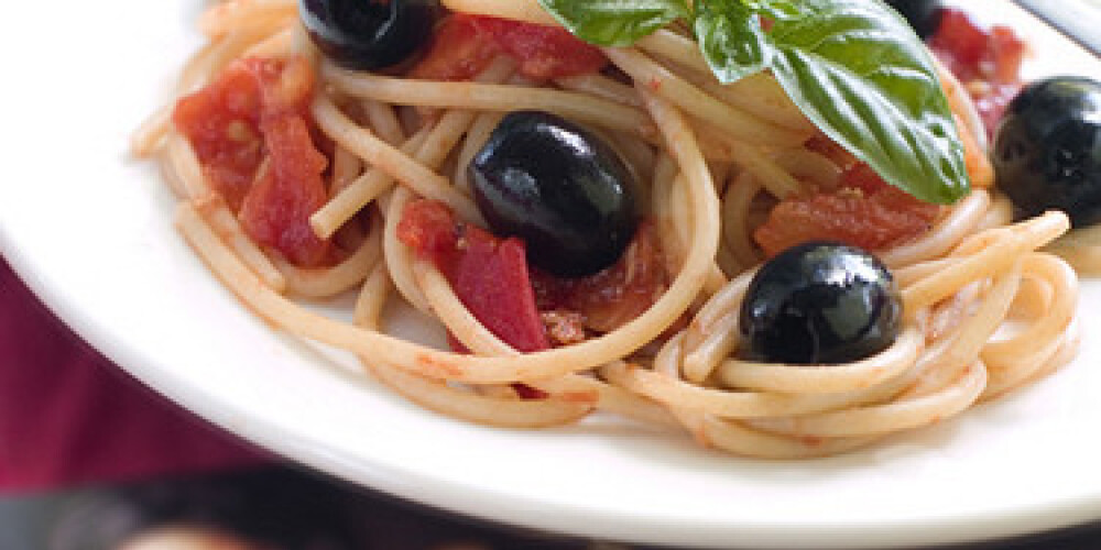 Spaghetti with tomatoes, black olives and basil. Selective focus
