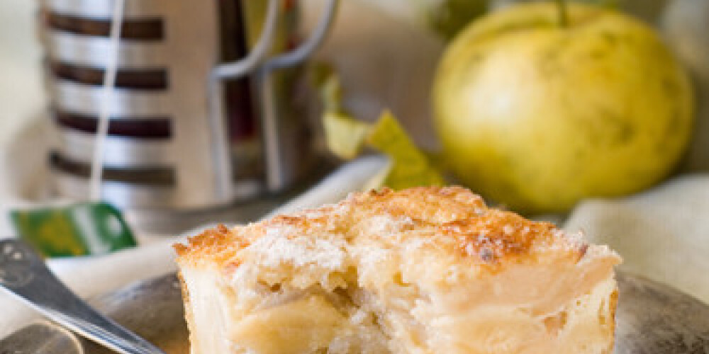 A slice of apple cake and cup of tea. Soft focus