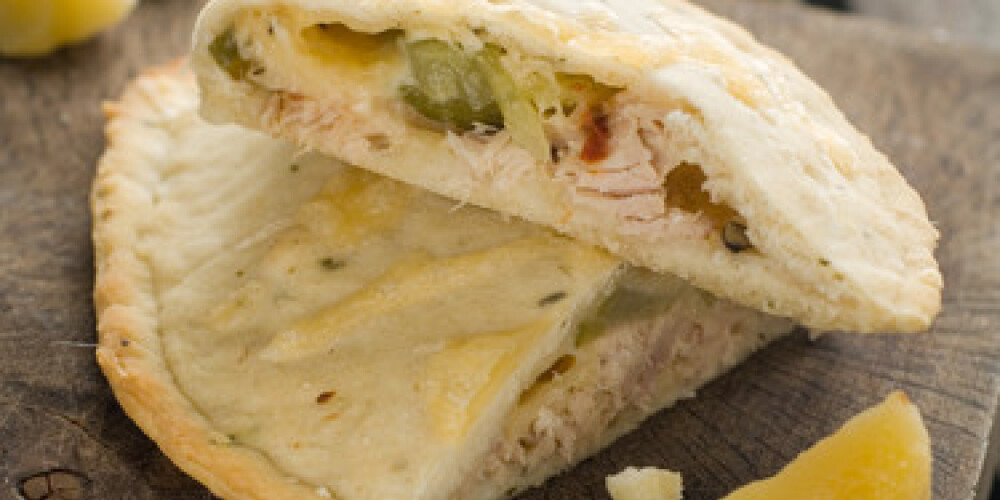 Calzone pizza with tuna on a wooden table, selective focus