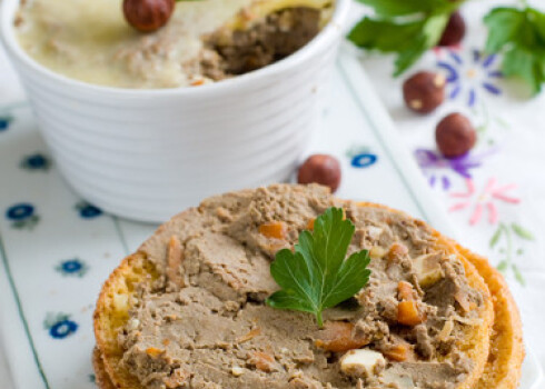 Bread with liver pate in a white ramekin with antique silver knife.