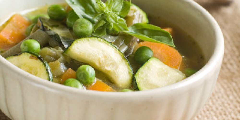 Minestrone soup with celery, carrots, onions, green beans and zucchini, selective focus