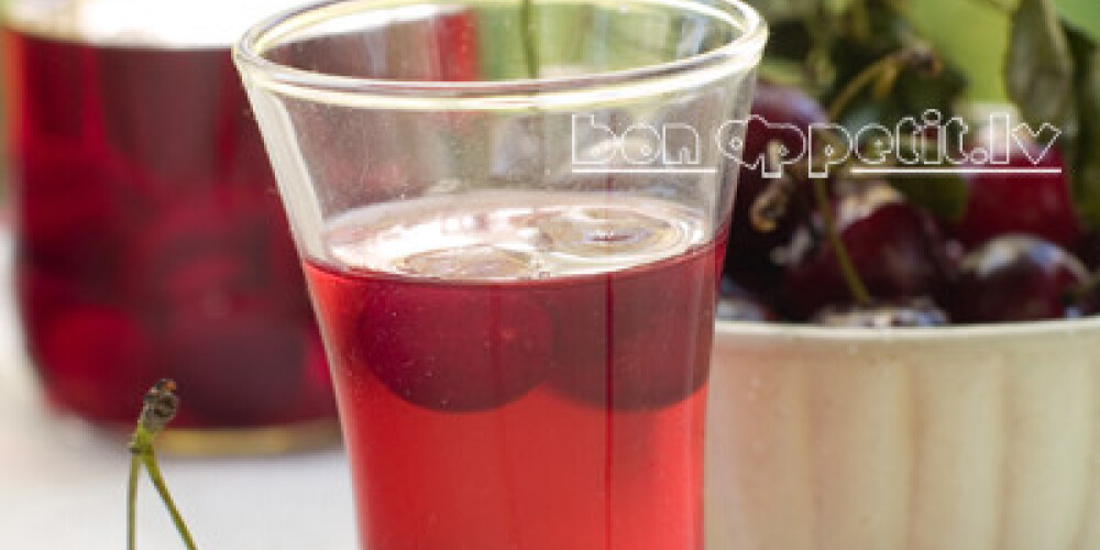 Cherry liqour in glass on natural background. Selective focus