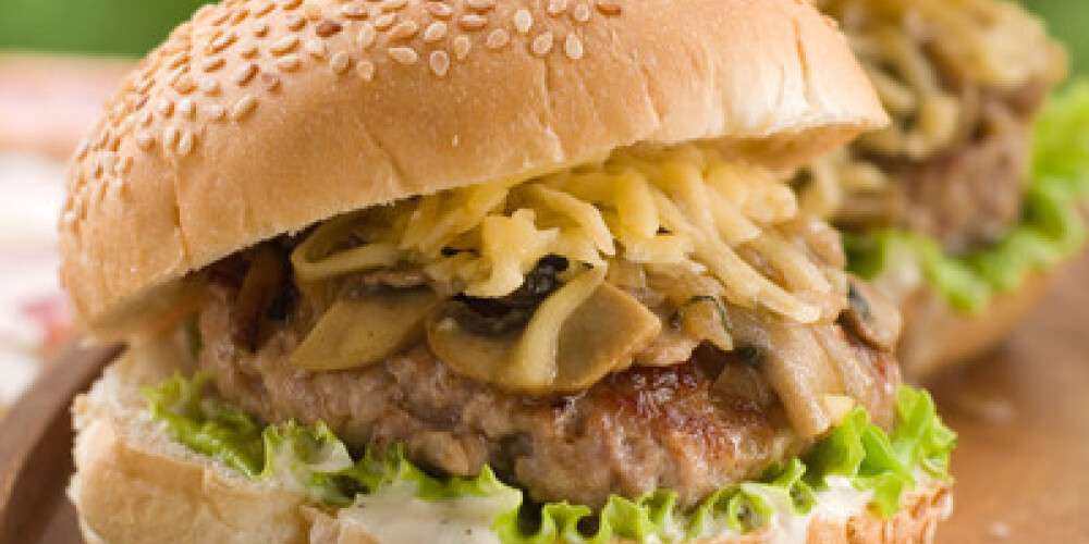 Juice hamburger with sauce on wooden plate, selective focus