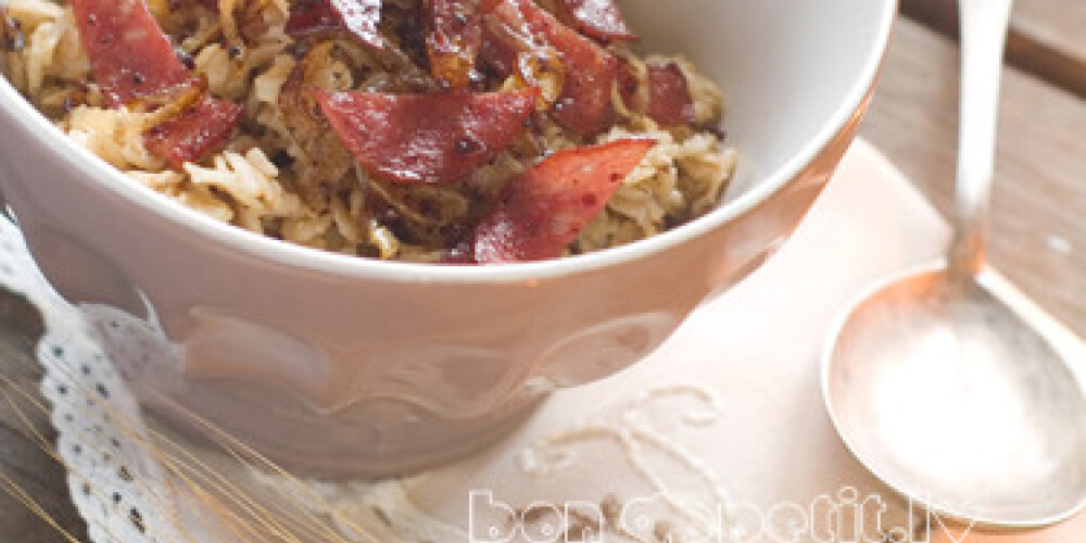 A bowl of warming porridge, with  bacon and onion, selective focus