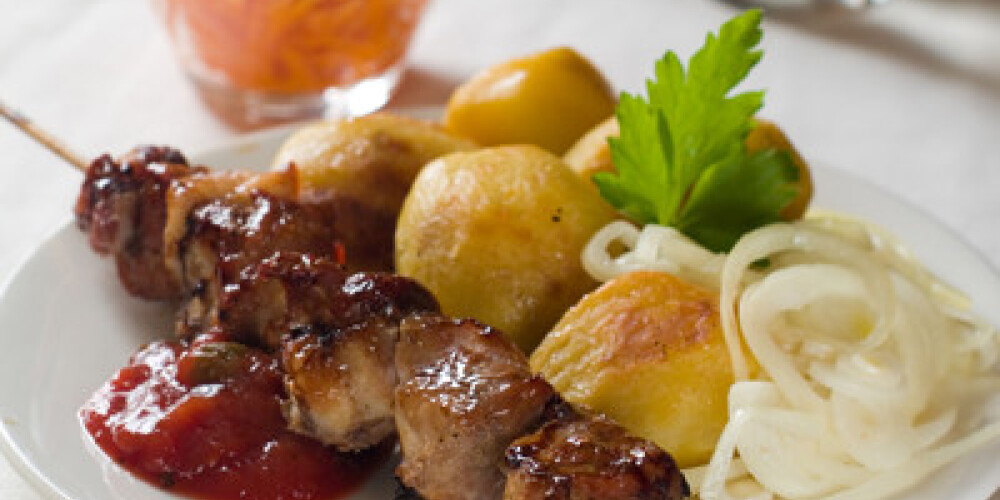 Pork kebab with potato, onion and tomato sauce, selective focus