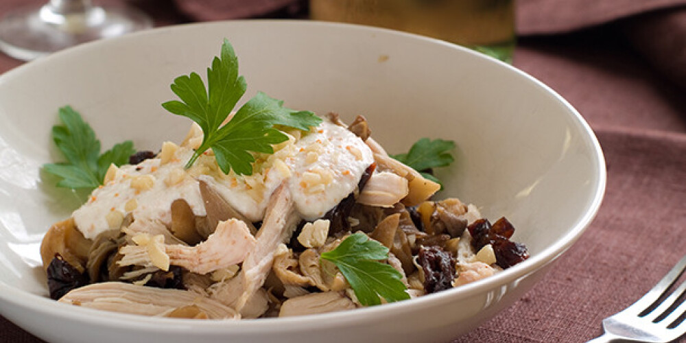 Salad with chicken, mushrooms,  prune and nut, selective focus