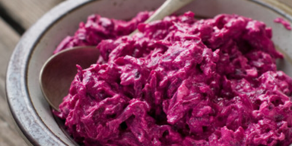 A bowl of beet salad with garlic and nuts, selective focus