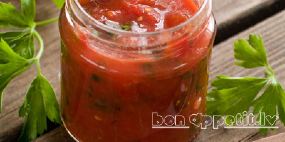 Tomato sauce (jam) with pepper, parsley and garlic in glass jar, selective focus, shallow doff