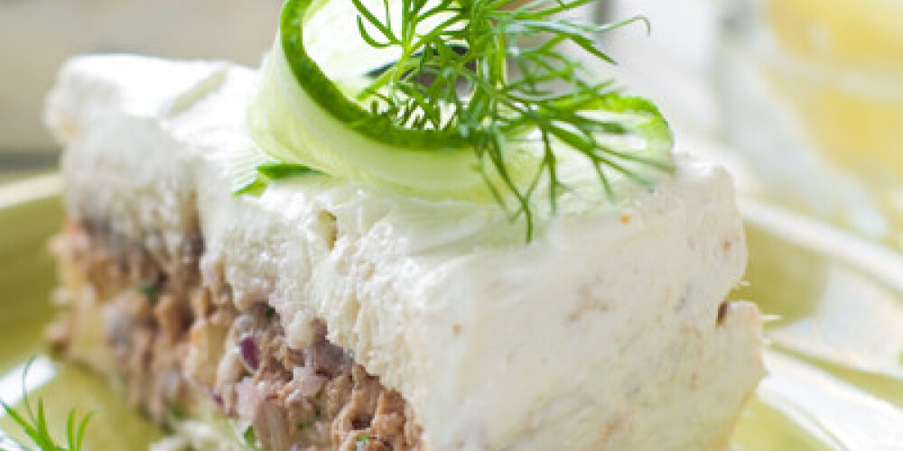 Slice of sandwich cake with tuna and cucumber, selective focus