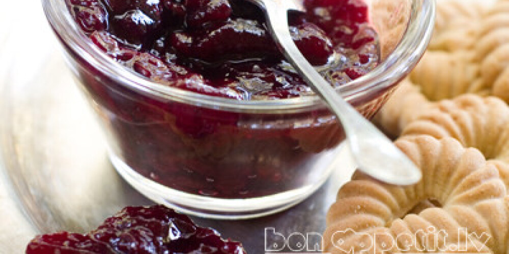 Fruit and berry jam in bowl with cookies, selective focus