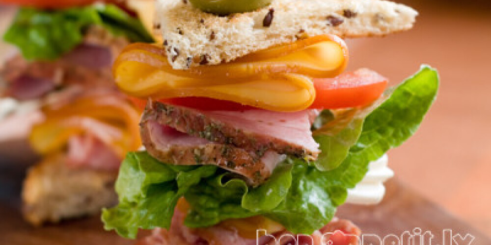 Sandwich with ham, sausage, cheese, tomato and lettuce, selective focus