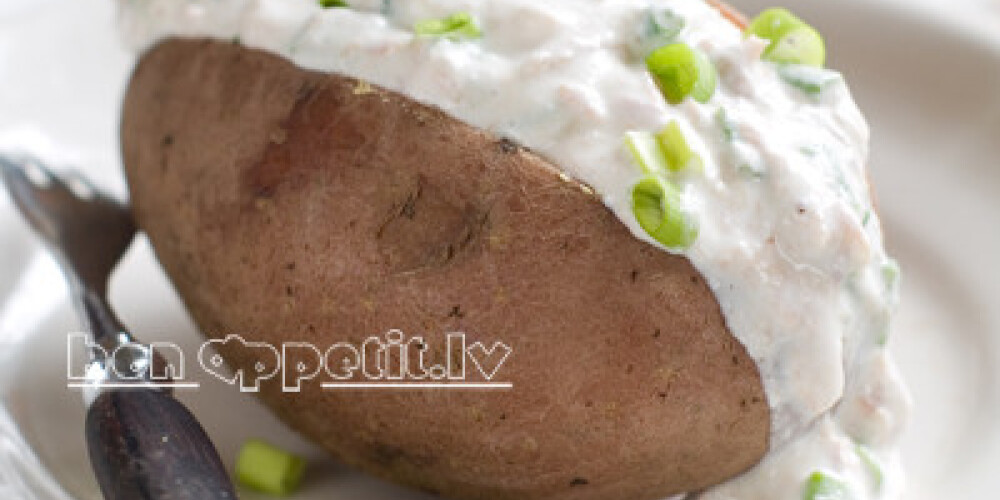 Baked potato with yoghurt sauce, selective focus