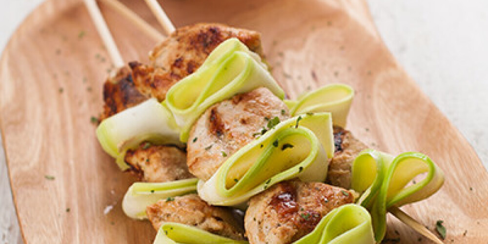 Grilled chicken and zucchini kebabs with sauce, selective focus