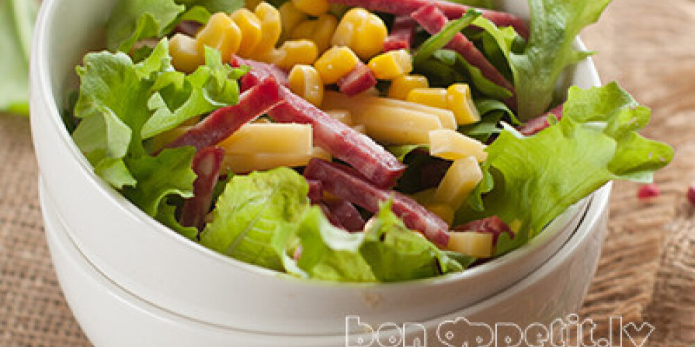 Salad with corn, cheese and sausage, selective focus