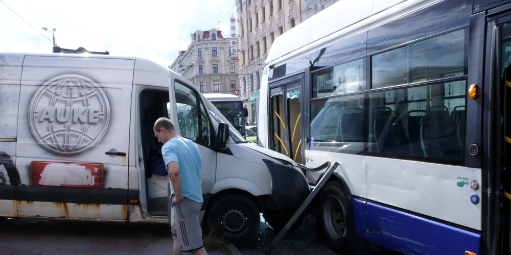 Foto: stāvēšanai novietots mikroautobuss Rīgas centrā ieripo braucošā trolejbusā