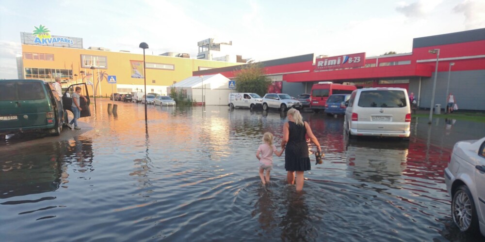 Foto: pamatīgs lietus Jūrmalā, lielveikala stāvvieta grimst ūdenī