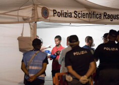 Poicisti Sicīlijā pārbauda migrantu, kurš nokāpis no "Frontex" kuģa.