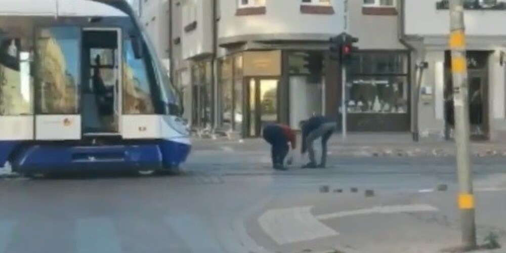VIDEO: garāmgājējs palīdz tramvaja vadītājai no sliedēm Barona ielā nolasīt sacēlušos bruģi