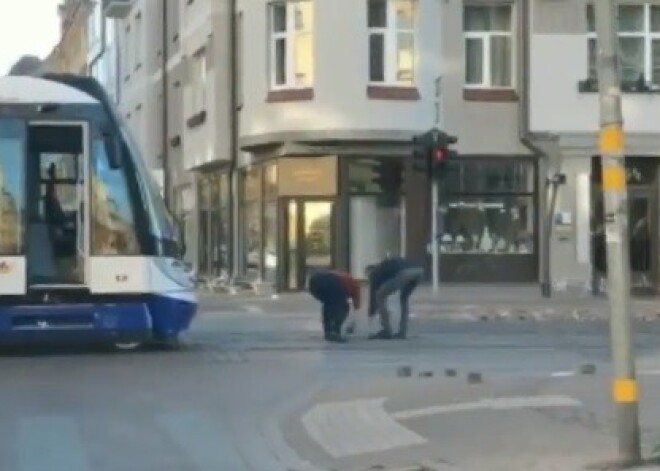 VIDEO: garāmgājējs palīdz tramvaja vadītājai no sliedēm Barona ielā nolasīt sacēlušos bruģi