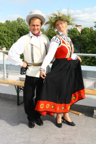 Kompānijas "Mikrofona ieraksti" dibinātāji Guntars Račs un Elita Mīlgrāve 2007. gada vasarā uz ēkas jumta terases, prezentējot savu jauno biroju.