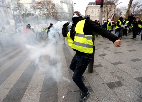 epa07216279 A Yellow Vests protester hurls an object to police forces during a demonstration near the Champs Elysees in Paris, France, 08 December 2018. Police in Paris is preparing for another weekend of protests of the so-called 'gilets jaunes' (yellow vests) protest movement. Recent demonstrations of the movement, which reportedly has no political affiliation, had turned violent and caused authorities to close some landmark sites in Paris this weekend.  EPA/IAN LANGSDON