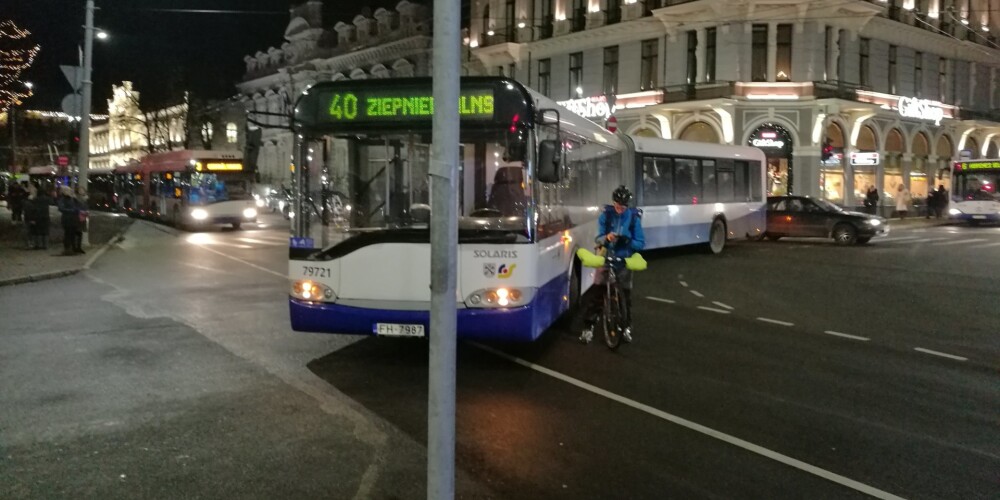 FOTO: velosipēdists pēc sadursmes ar autobusu gaida policiju un atsakās kustēties, paralizējot satiksmi Rīgas centrā