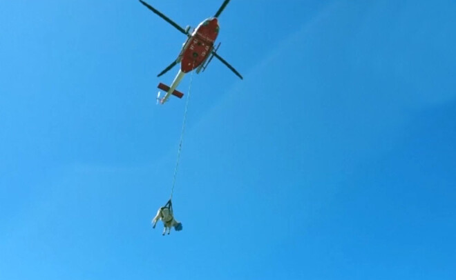 Ugunsdzēsēji ar helikopteru nogādā drošībā govi.